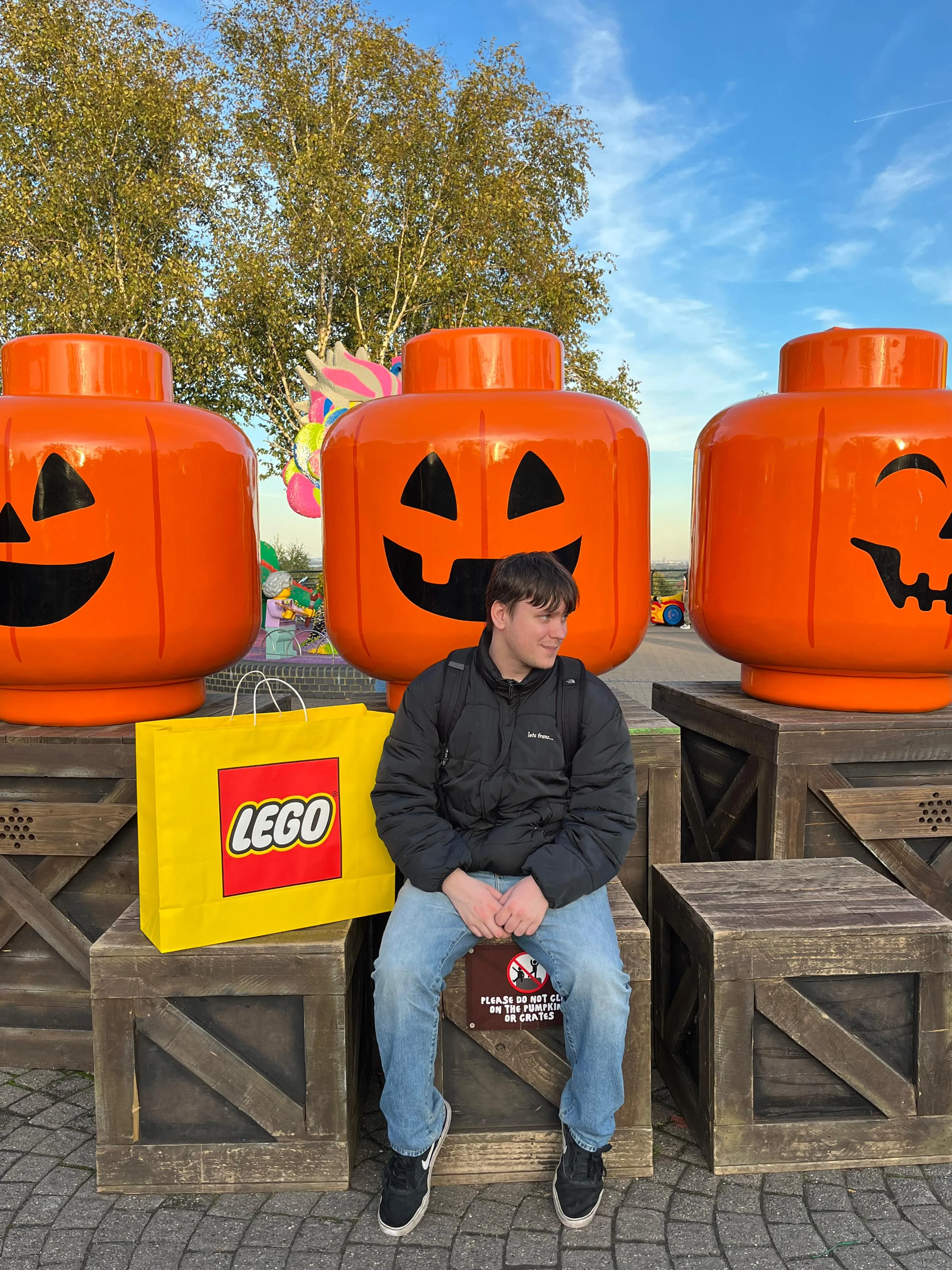 Gabriel Dorosh seated beside large orange LEGO figures in Japan